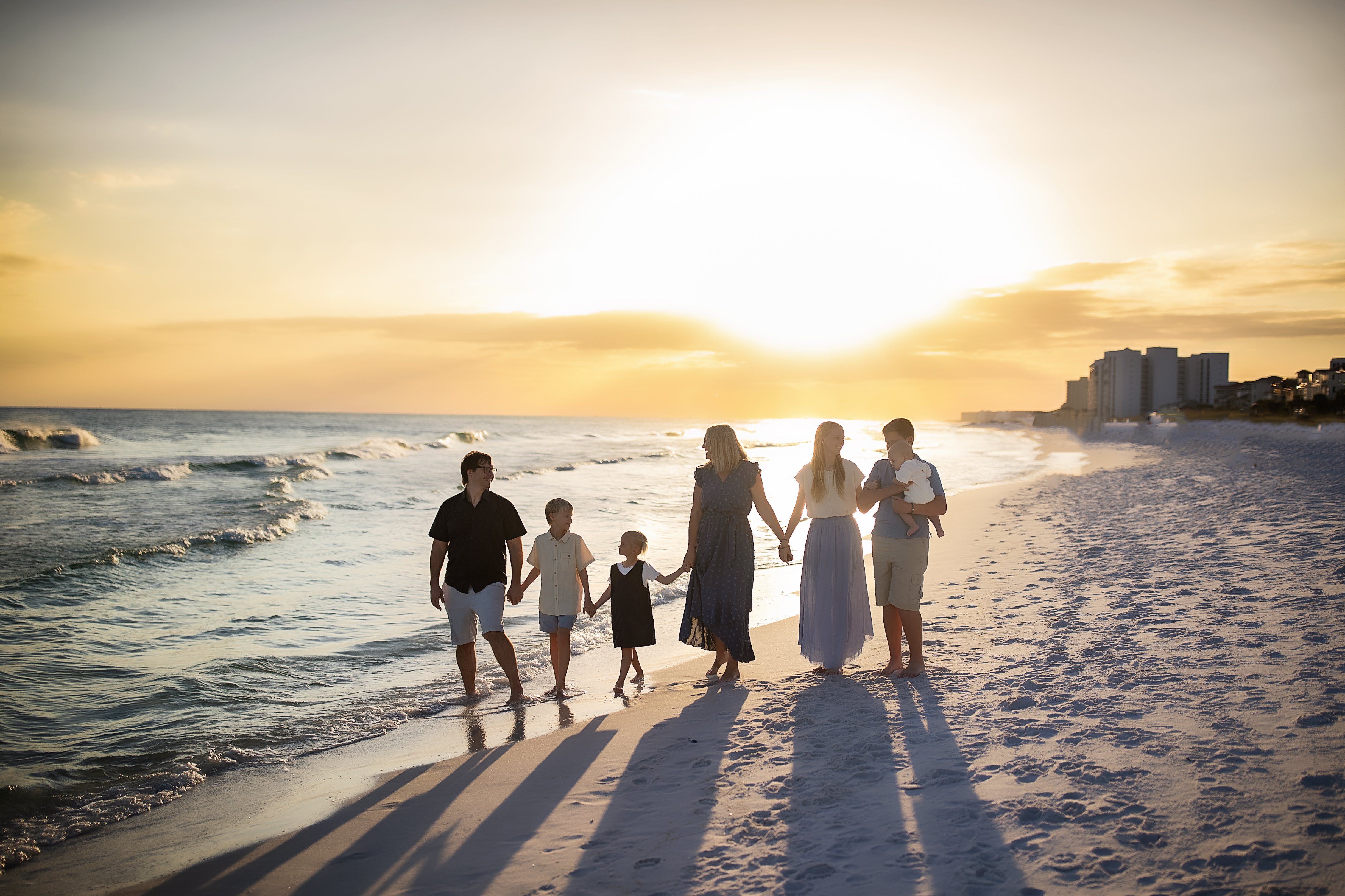 Fleming family walking along the beach at sunset